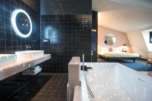 een badkamer met een bad en een bed in een kamer bij The Dutch Maastricht in Maastricht