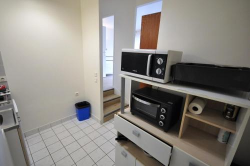 - une cuisine avec 2 fours micro-ondes sur un comptoir dans l'établissement Nice 36 m2 - Parc des Buttes Chaumont!, à Paris