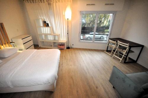 une chambre avec un lit, un bureau et une fenêtre dans l'établissement Nice 36 m2 - Parc des Buttes Chaumont!, à Paris
