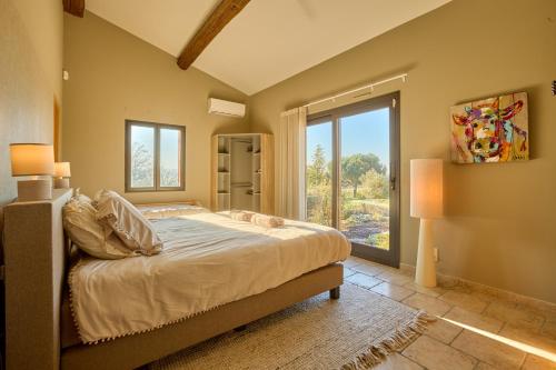 Un dormitorio con una cama y una ventana grande en Villa du Monde - 160 m² avec piscine privée, en Saint-Rémy