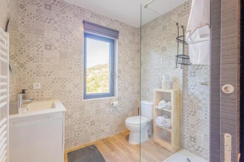 a bathroom with a toilet and a sink and a window at La Casa Di Castagni - Climatisé avec terrasse in Oletta