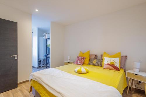 a bedroom with a yellow bed with two tennis balls on it at La Casa Di Castagni - Climatisé avec terrasse in Oletta
