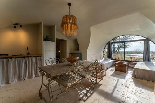 une cuisine avec une table et des chaises dans une pièce dans l'établissement La Bastide d'Engras - 170 m2 avec piscine privée, à La Bastide-dʼEngras