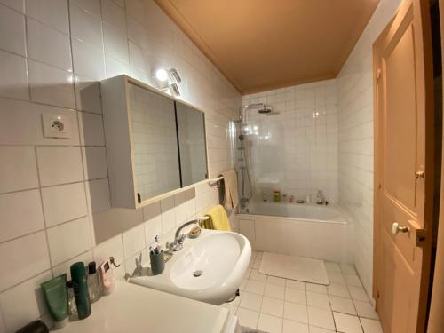 une salle de bain blanche avec un lavabo et un miroir dans l'établissement Magnifique appartement avec terrasse à côté de la Tour Eiffel, à Paris