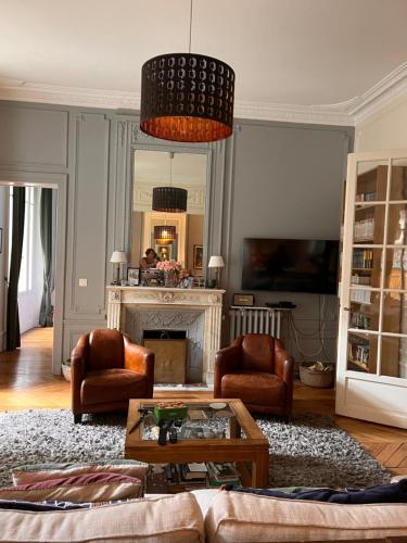 - un salon avec un canapé, des chaises et une cheminée dans l'établissement Magnifique appartement avec terrasse à côté de la Tour Eiffel, à Paris