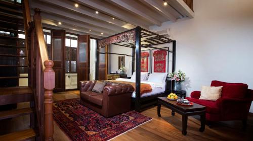 a bedroom with a bed and a couch and a chair at Seven Terraces in George Town