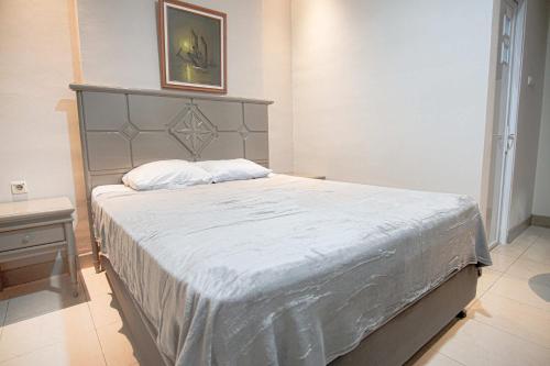 a bedroom with a large bed with a gray headboard at Hotel Permata Malioboro in Yogyakarta