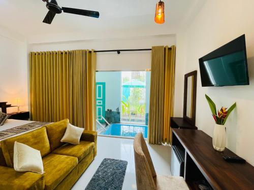een woonkamer met een bank en een groot raam bij Kingsman Villa in Mirissa