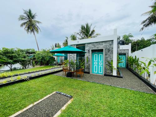een huis met een gazon ervoor bij Kingsman Villa in Mirissa
