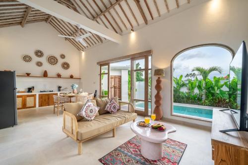 a living room with a couch and a table at Bambola - Stunning New Luxury Villa in Kerobokan with Expansive Pool - Your Dream Home Awaits! in Canggu
