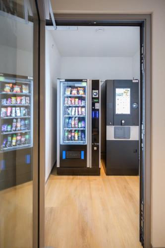 a drink vending machine in a room with drinks in it at Hôtel Arnold self check-in in Neuchâtel