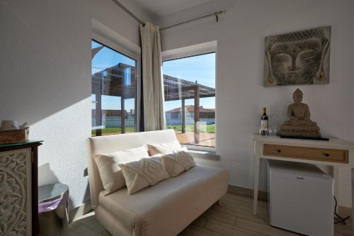a living room with a chair and a window at A Casa Branca - with Pool & Jacuzzi in Santa Comba Dão