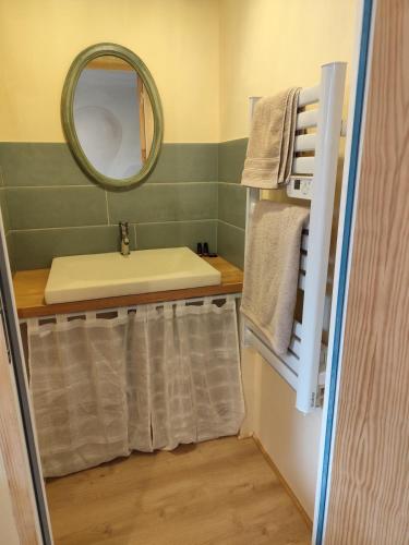 une salle de bain avec un lavabo, un miroir et des serviettes dans l'établissement Studio avec mezzanine, à Mamers