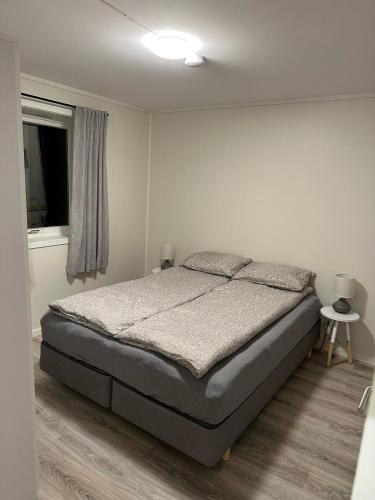 a bedroom with a bed and a window at Aurora apartment Nygård in Sletta