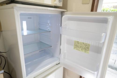 an empty refrigerator with its door open in a kitchen at Seeds Stay Ijiri in Fukuoka