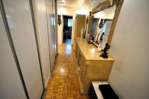 une salle de bain avec un lavabo et un grand miroir dans l'établissement Spacious, Bright Apartment with Private Parking, à Paris