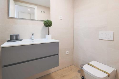 a bathroom with a sink and a toilet and a mirror at Casa Madreselva by Rental Hero in Las Casicas