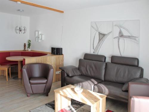un salon avec un canapé et une table dans l'établissement Ferienhaus Nr 27, Kategorie Premium, Feriendorf Hochbergle, Allgäu, à Lechbruck am See