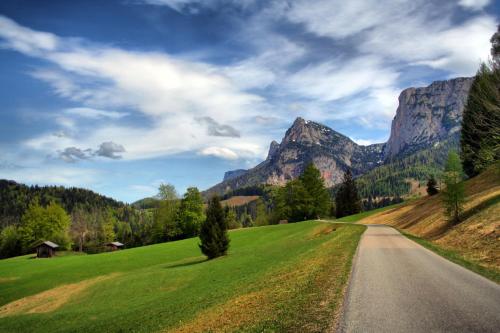a road in a field with mountains in the background at Appartements Schmidsendl in Lofer