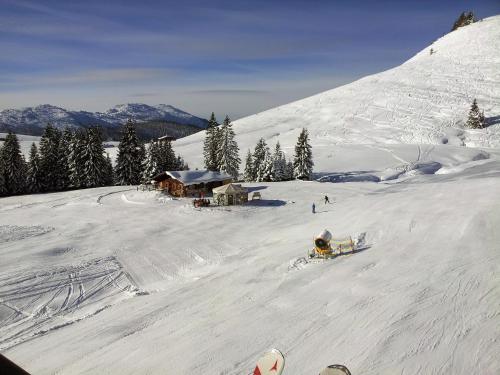 a person riding a snowboard down a snow covered slope at Appartements Schmidsendl in Lofer