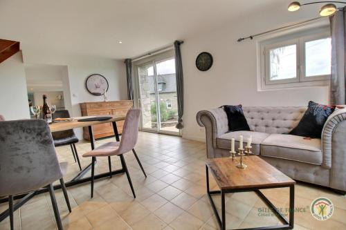 un salon avec un canapé et une table dans l'établissement La forge de la fontaine, à Pléhédel