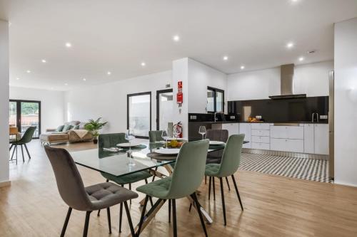 a kitchen and dining room with a glass table and chairs at VIRA by KAAMAH in Estreito de Câmara de Lobos