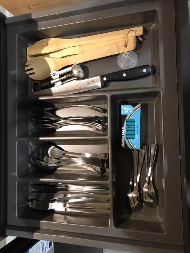 un tiroir rempli d'ustensiles en argent dans un tiroir dans l'établissement Le chalet de Lenny- spa- borne recharge- wifi, à Luçay-le-Mâle