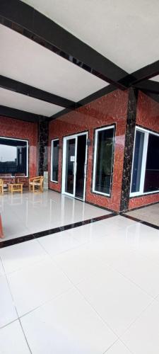 a room with a brick building with tables and windows at Nesya 2 in Campaka