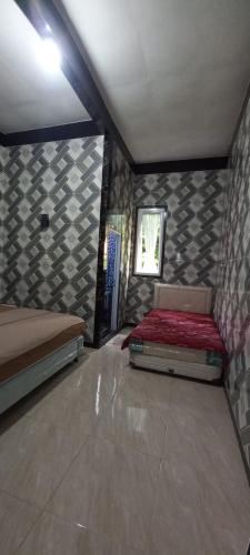 a room with two beds and a window in it at Nesya 2 in Campaka