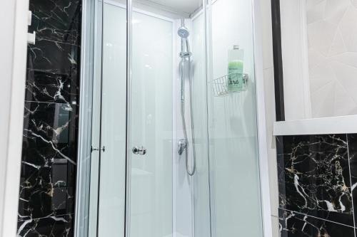 a shower with a glass door in a bathroom at 3 Stylish Studios at a Great Location in Gent in Ghent