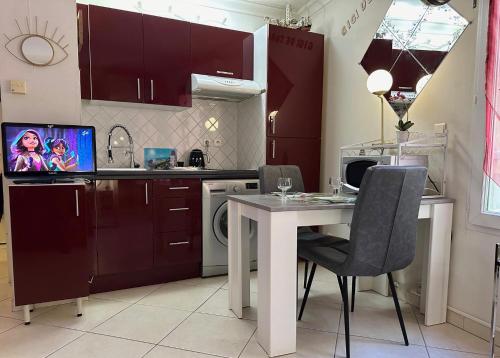cocina con mesa con sillas y microondas en CANNES CENTRE 5 minutes de la mer, en Cannes