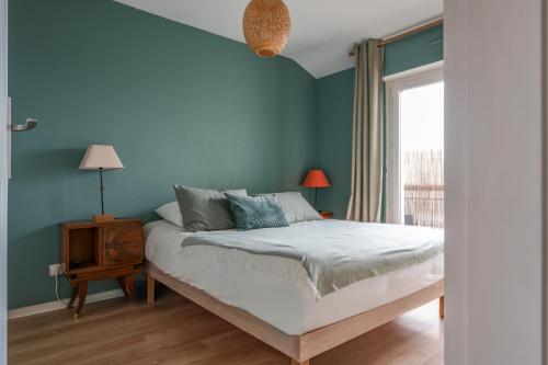 ein blaues Schlafzimmer mit einem Bett und einem Fenster in der Unterkunft Maison familiale jardin terrasse proche lac Joué in Joue-les-Tours