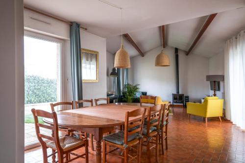 une salle à manger avec une table et des chaises en bois dans l'établissement Maison familiale jardin terrasse proche lac Joué, à Joué-lès-Tours