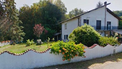 a house with a garden and a wall at Casa Vacanze Nonna Papera near Cinque Terre in Bolano