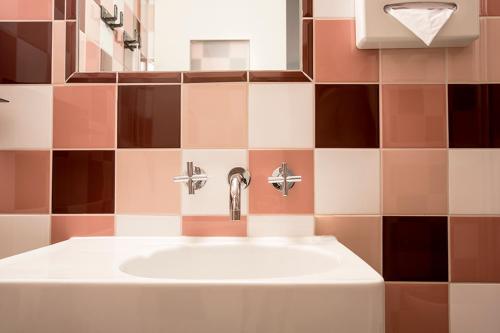 a bathroom with a sink and a mirror at The Dutch Maastricht in Maastricht