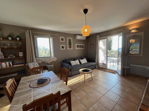 a living room with a table and a couch at Gites Mas Du Cadranier in Villeneuve