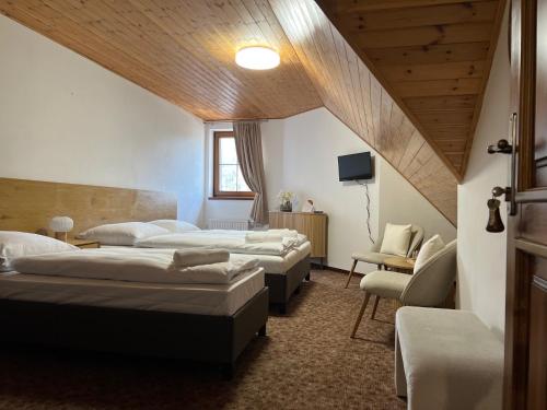 una camera con tre letti e una sedia di Villa Bella a Špindlerův Mlýn