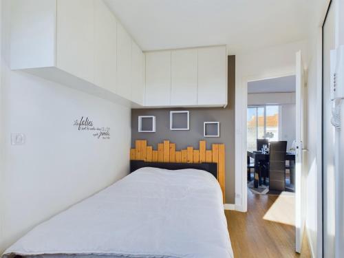 une chambre avec un grand lit blanc et une cuisine dans l'établissement Appartement pour 4 avec balcon et terrasse, à Les Sables-dʼOlonne