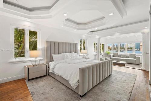 a white bedroom with a large bed and a living room at Waterfront Paradise 4 BD Villa Miami Breeze with Pool in Miami