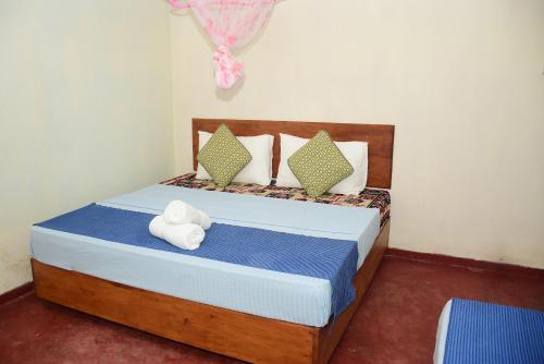 a bedroom with a bed with towels on it at Rosa Villa in Galle