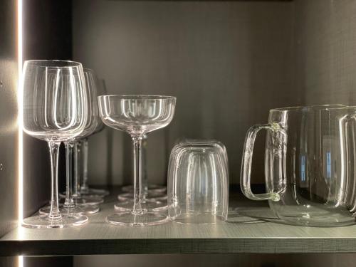 une rangée de verres à vin assis sur une étagère dans l'établissement mmm - 19LA - Suites de Luxe - Centre de Lyon, à Lyon