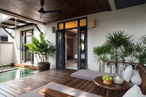 an outdoor living room with a pool and a patio at Anantara Lawana Koh Samui Resort in Chaweng
