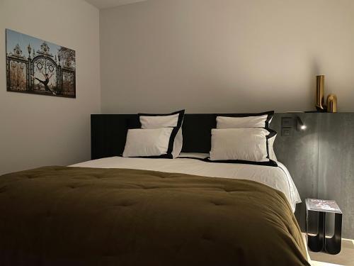 une chambre avec un grand lit avec des oreillers blancs dans l'établissement mmm - 19LA - Suites de Luxe - Centre de Lyon, à Lyon