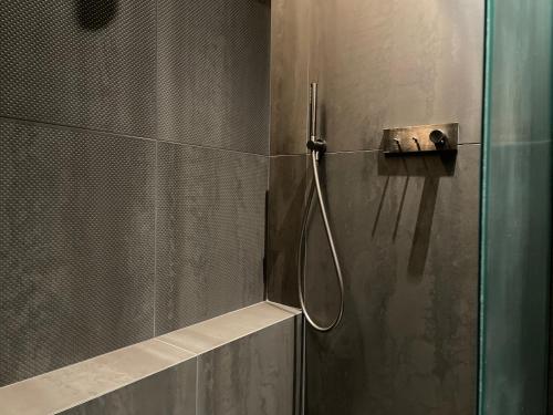une douche dans une salle de bain avec une porte vitrée dans l'établissement mmm - 19LA - Suites de Luxe - Centre de Lyon, à Lyon