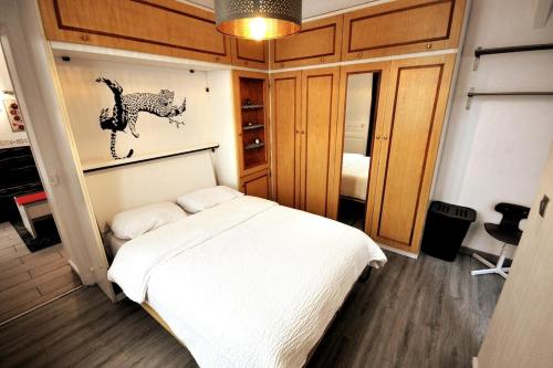 une chambre avec un lit blanc dans une pièce dans l'établissement Warm and comfortable studio in Montmartre, à Paris