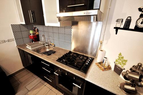 une cuisine avec un évier et une cuisinière four supérieur dans l'établissement Warm and comfortable studio in Montmartre, à Paris
