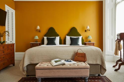 a bedroom with a large bed with yellow walls at Georgian House Hotel in London