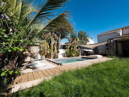 une piscine dans une cour à côté d'une maison dans l'établissement Maison de la Bonaventure Pérols, piscine et jardin, à Pérols