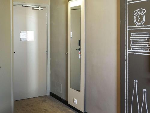a bathroom with a mirror next to a door at Ibis Sfax in Sfax
