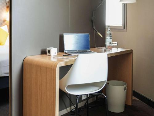 a desk with a laptop computer on top of it at Ibis Sfax in Sfax